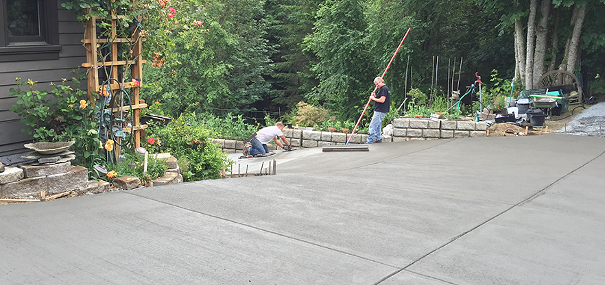 Artistic Concrete installing a new slate Integral colored concrete driveway with a fine tbroom finish in the Camano Island area.